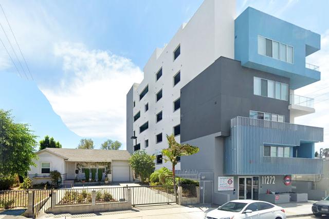 Architect's drawing of a large building next to a single family home.